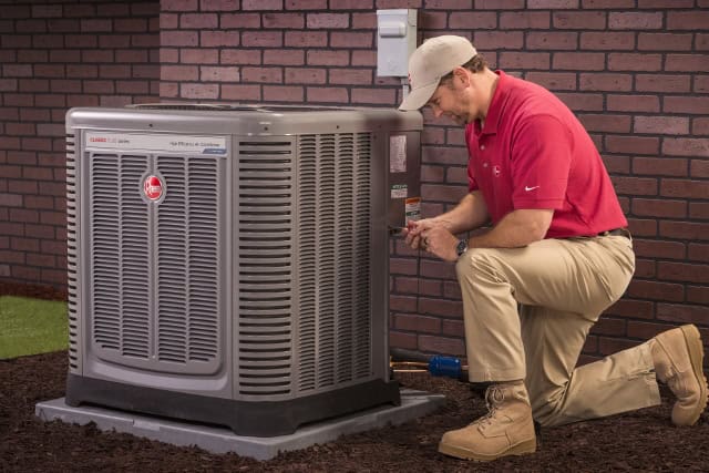 Bry Heat and Air technician servicing a Rheem air conditioner